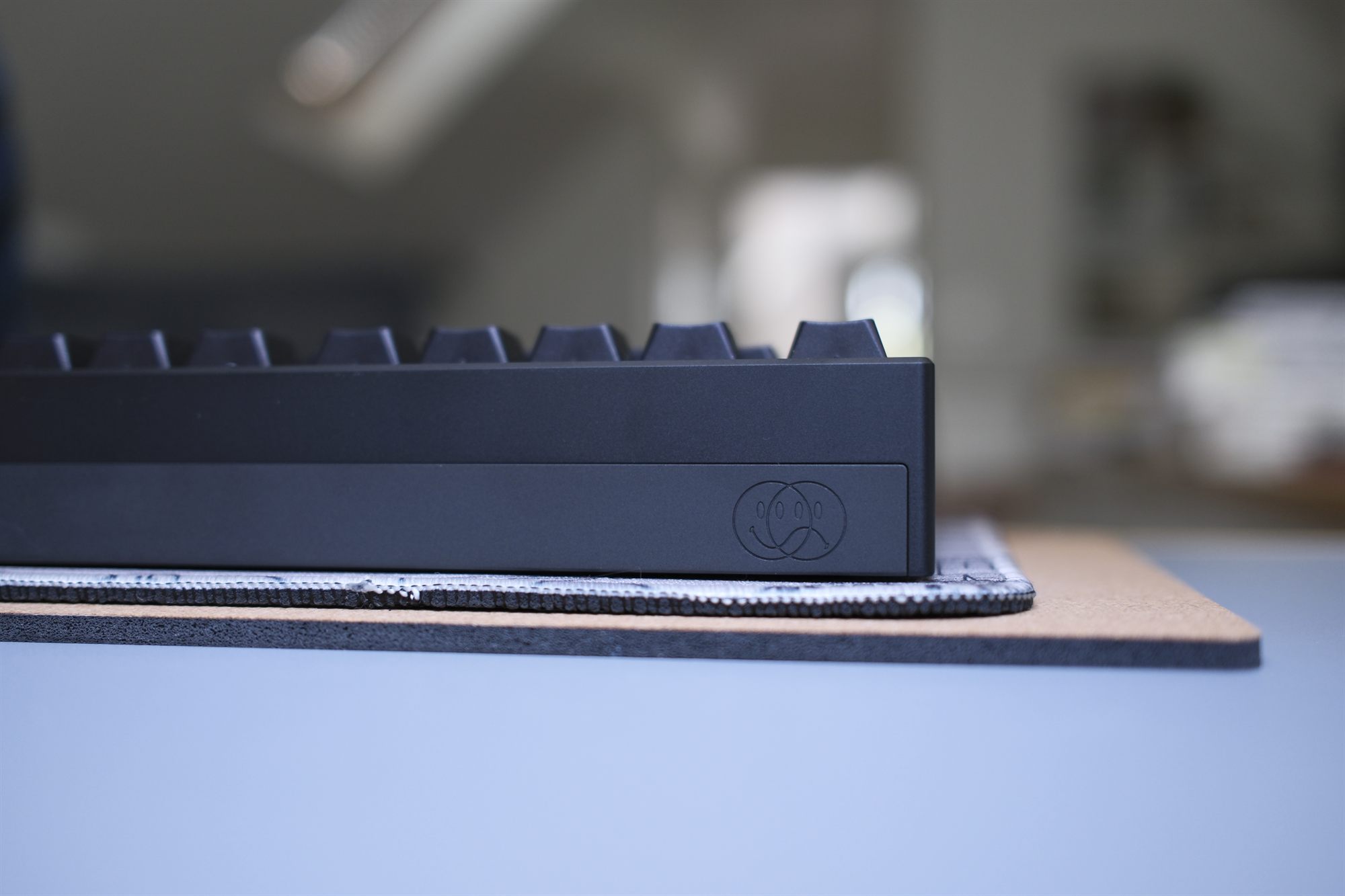 Cruel World CW88, low front profile — matte black case with monochrome GMK Cosmos keycaps and an embossed badge