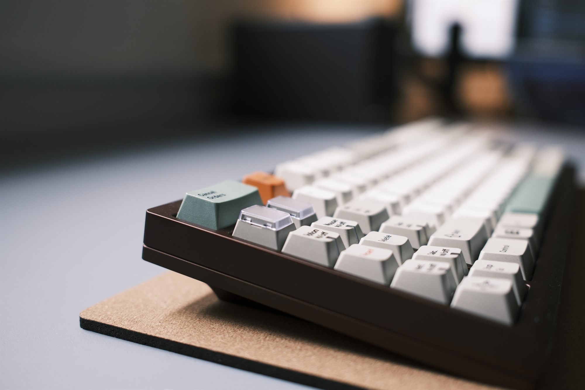 Diversity TKL, three-quarter view — chocolate-brown case with GMK 9009-style greyscale caps, an orange PANIC key and clear macro keycaps