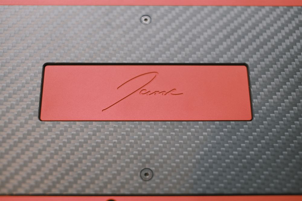 Carbon-fibre back and red plate with the engraved Jane signature