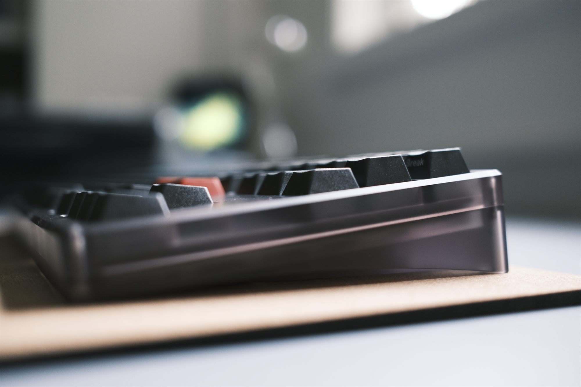 NRD Kaze keyboard, three-quarter view — translucent smoke polycarbonate case with dark Dolch keycaps and a red accent