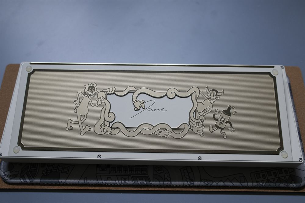 Underside gold PVD mirror weight with engraved cartoon characters and signature