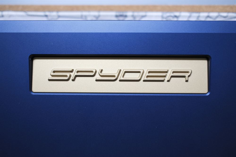 Macro of the gold SPYDER nameplate against the gentian-blue anodize